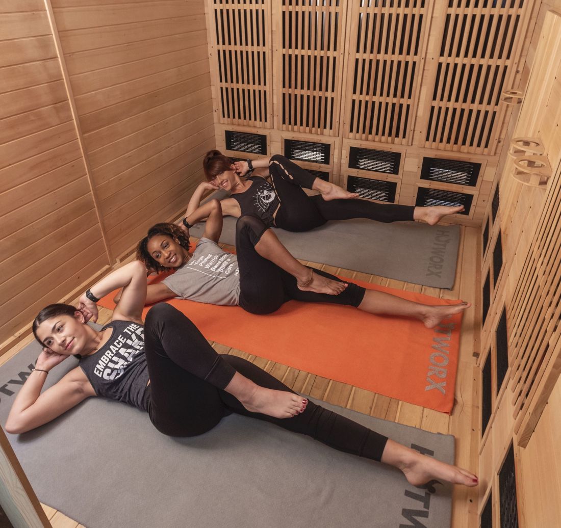 Three women doing core work in a HOTWORX sauna
