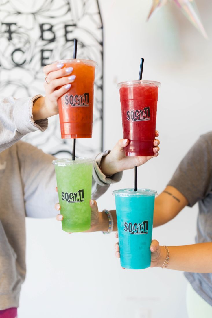 Four colorful Social drinks held up together